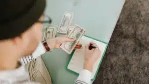 Individual budgeting with US dollars and a planner, focusing on financial planning.