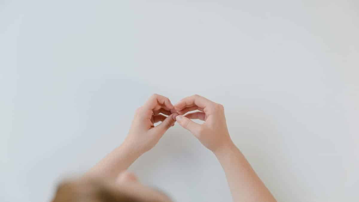 Hands of a person forming a heart shape, symbolizing love and communication through sign language.