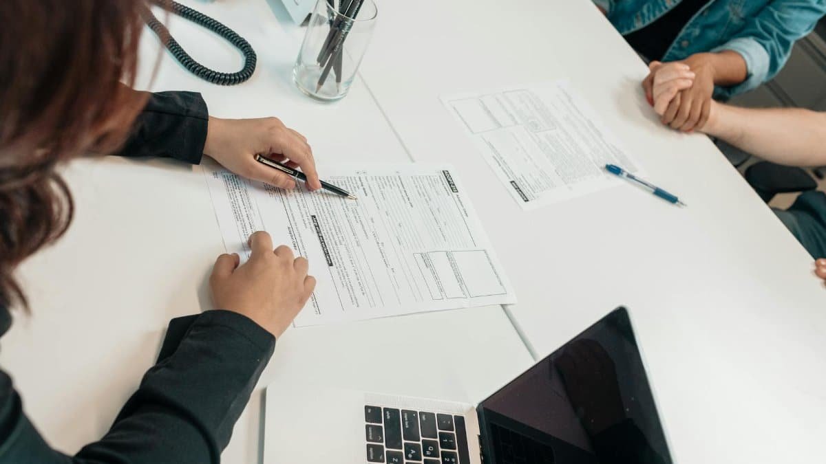 A professional meeting with document signing at an office desk, focusing on teamwork.