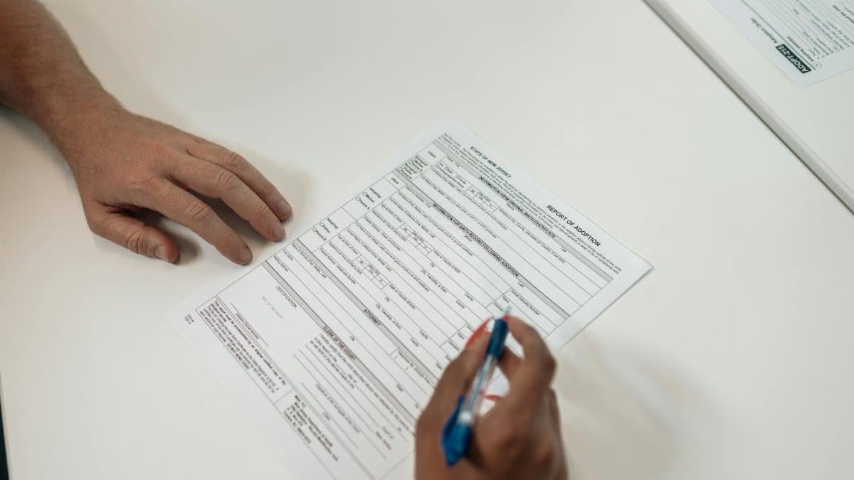 Two people reviewing and signing adoption documents, symbolizing legal procedures and family planning.