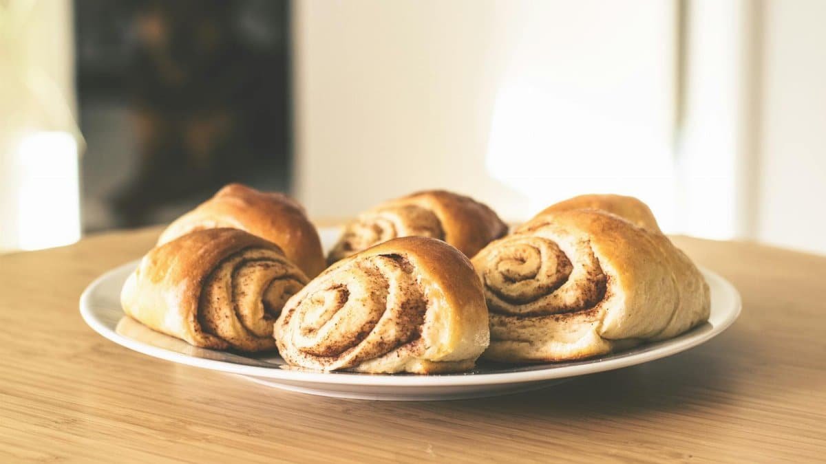 Warm and inviting cinnamon rolls on a white plate, perfect for a sweet treat.