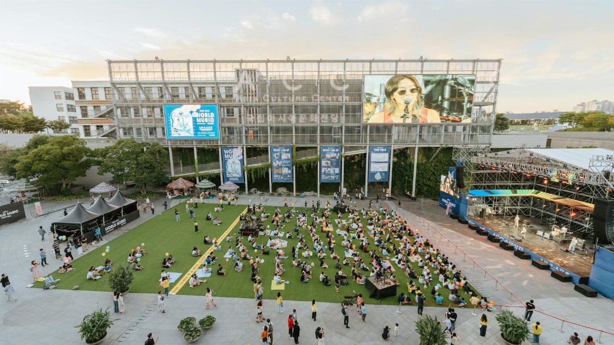 A lively outdoor music concert featuring an enthusiastic crowd at a cultural center.