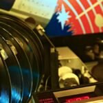 Close-up of a retro jukebox featuring vinyl records and classic hits playing in a vibrant setting.