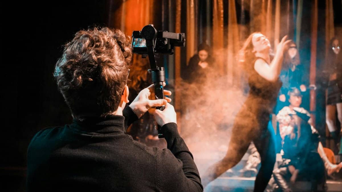 A photographer captures a live dance performance, emphasizing motion and atmosphere on stage.