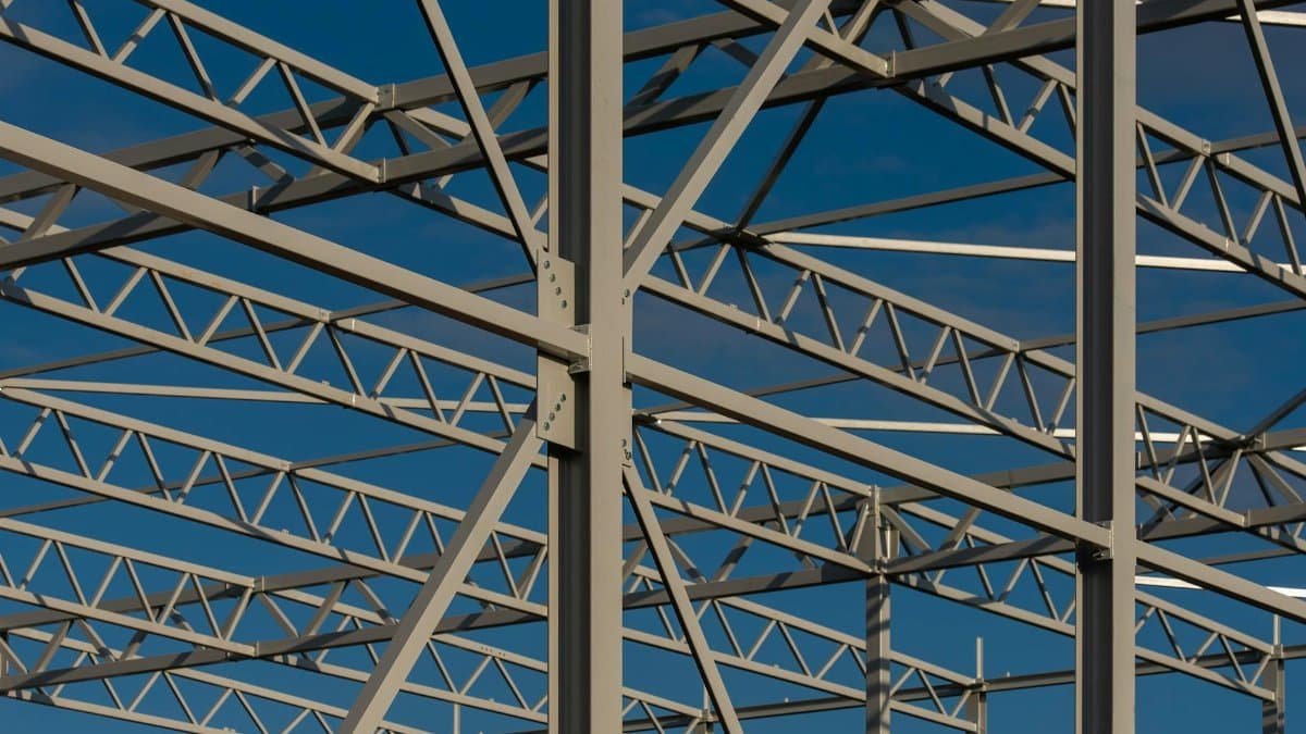 Detailed view of a steel framework structure against a blue sky, showcasing modern construction elements.