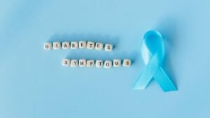 Conceptual image emphasizing diabetes symptoms with a blue awareness ribbon and letter dice.