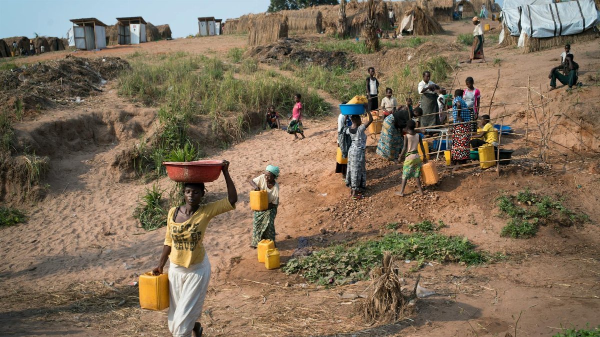 A group of villagers gathers water near Kalemie, DR Congo, showcasing daily rural life.