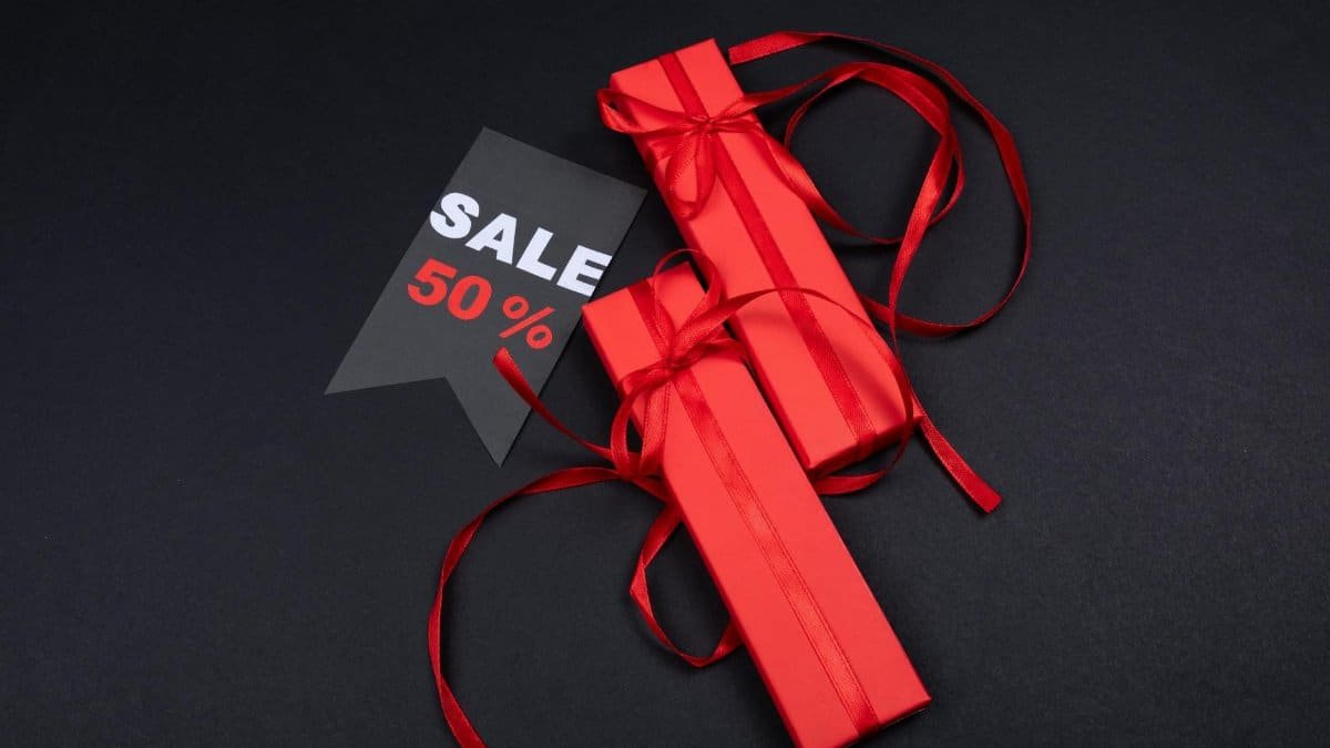 Red gift boxes with ribbons and a 50% sale tag on a dark background.