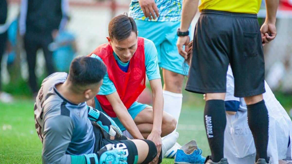 A soccer player receives assistance after an injury during a match in Hanoi, Vietnam.
