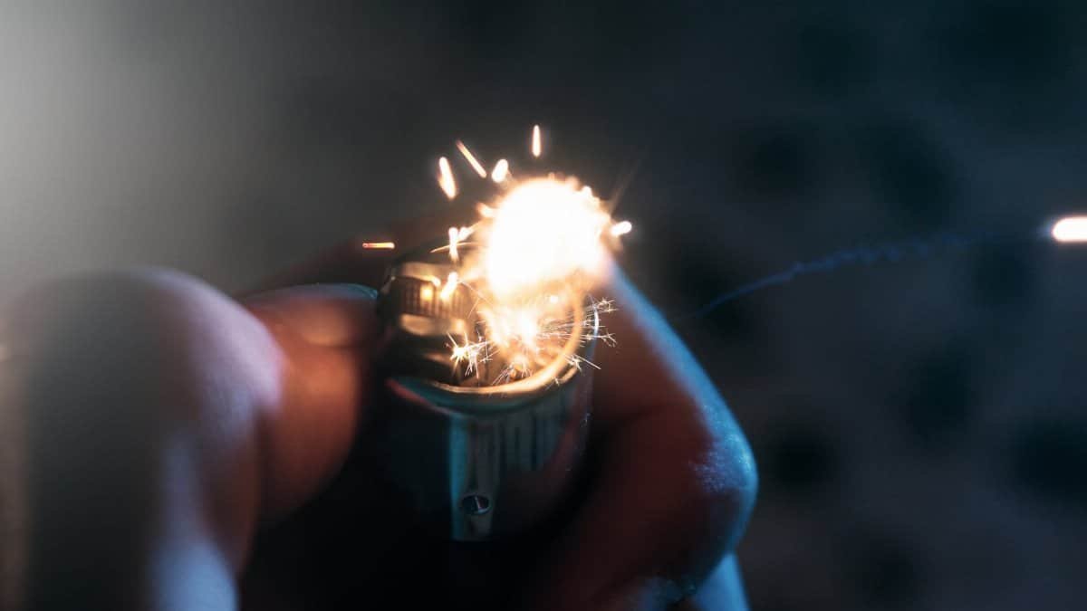 A macro shot showing a lighter being lit, with vibrant sparks in motion.