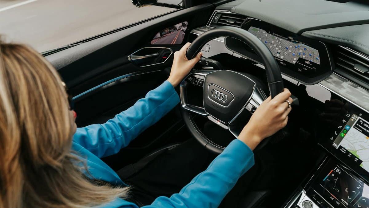 High angle view of a woman driving a modern Audi car, showcasing the dashboard and steering wheel.