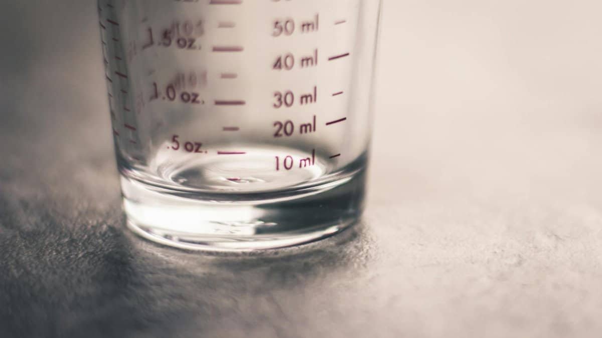 An artistic view of an empty measuring glass highlighting metric and ounce measurements.