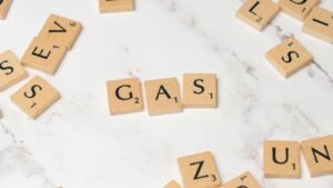 Scrabble tiles on marble spelling 'Gas', perfect for energy concept visuals.