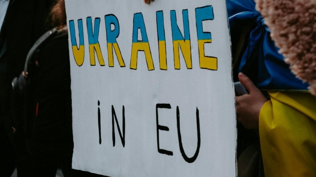 A protest sign advocating Ukraine's membership in the EU, held by demonstrators outdoors.