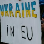 A protest sign advocating Ukraine's membership in the EU, held by demonstrators outdoors.