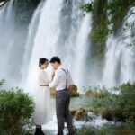 A couple shares a tender moment by the scenic Ban Gioc Waterfall in Cao Bang, Vietnam.