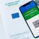 EU Digital COVID Certificate displayed on smartphone and paper form, vaccination proof.