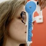 Optometrist using a blue measurement tool for vision assessment on a young female patient.