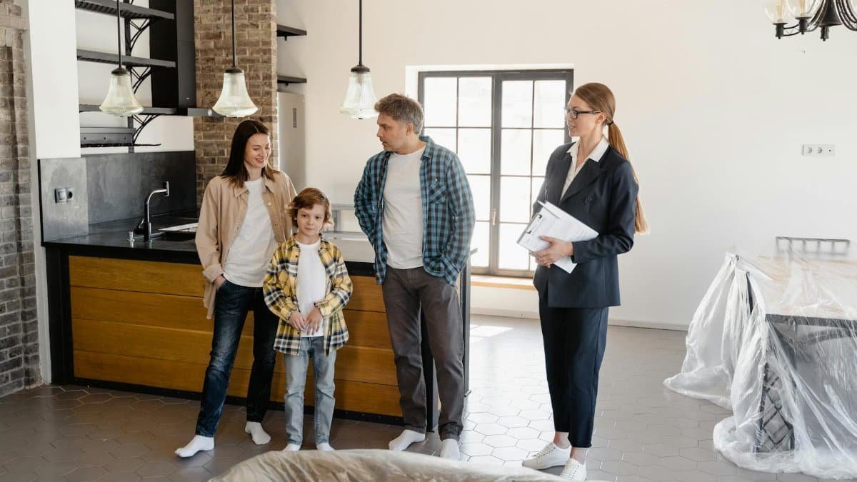 Family exploring a newly purchased home interior with real estate agent.