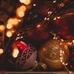 Festive Christmas ornaments surrounded by glowing fairy lights creating a warm holiday ambiance.