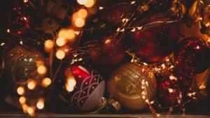 Festive Christmas ornaments surrounded by glowing fairy lights creating a warm holiday ambiance.