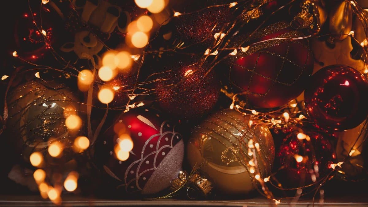 Festive Christmas ornaments surrounded by glowing fairy lights creating a warm holiday ambiance.