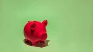 Red piggy bank on a green background symbolizing savings and financial planning.