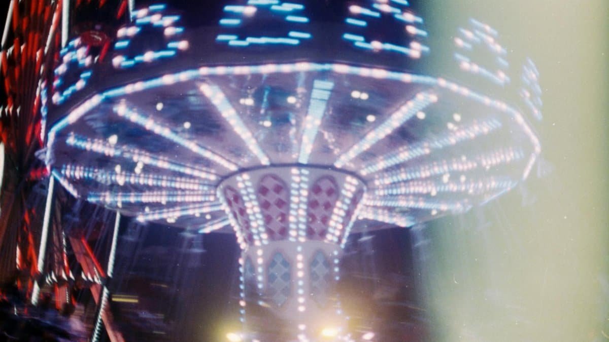 Dazzling long exposure of an illuminated amusement ride in Cluj-Napoca at night.