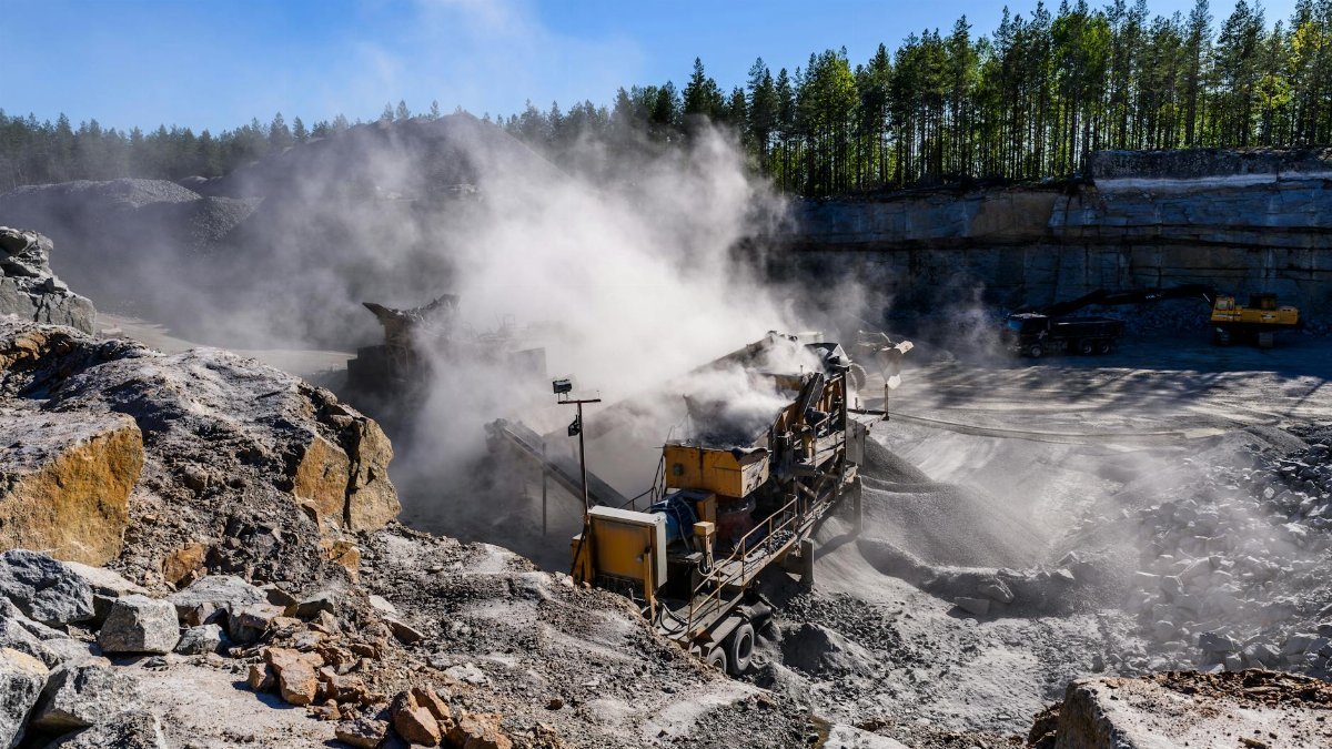 Excavation machinery in a dust-filled quarry in Honkajoki, Finland.