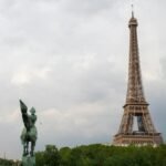 Iconic view of the Eiffel Tower alongside the equestrian statue La France Renaissante in Paris.