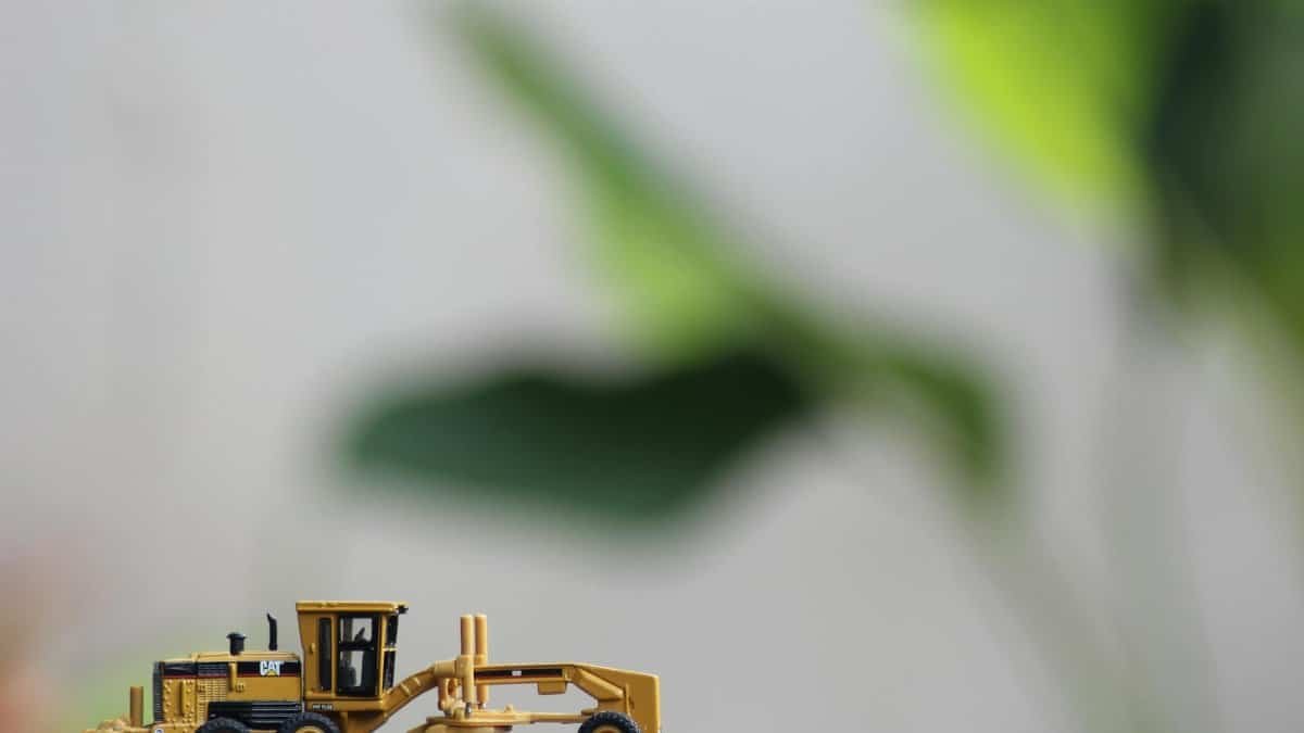 A detailed model of a construction vehicle against a blurred natural background.