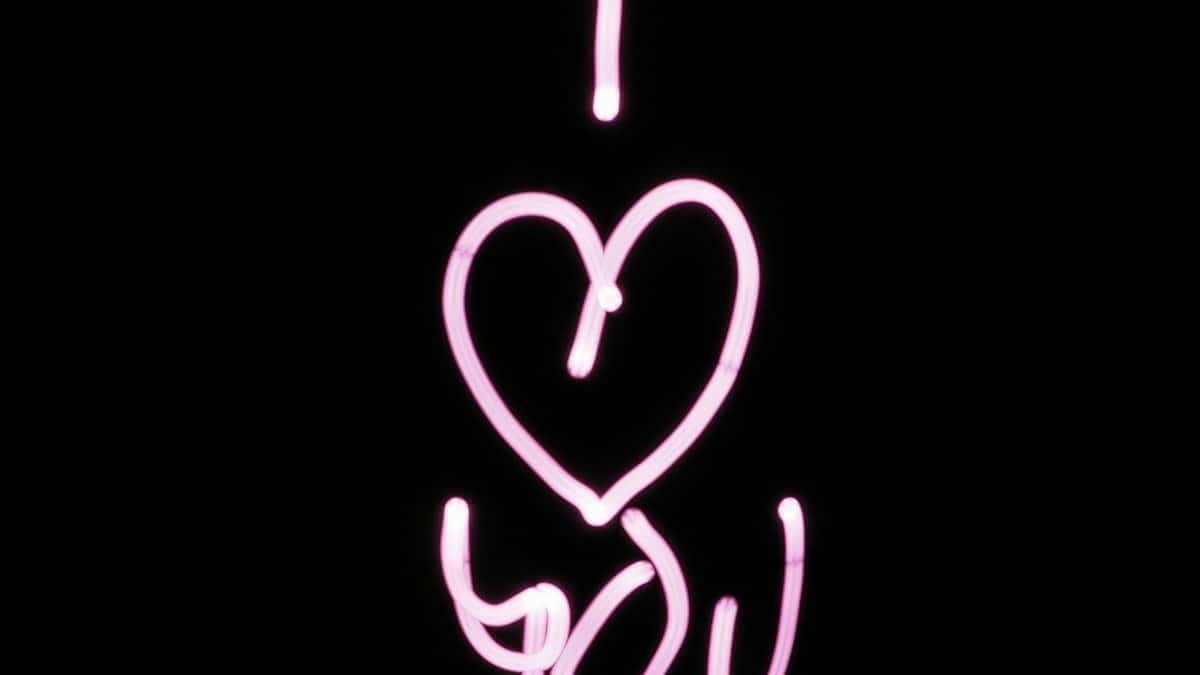 Bright pink light painting of 'I Love You' on a black background, perfect for Valentine's Day.