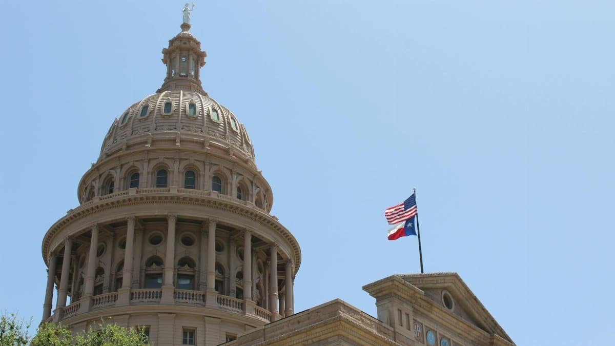 Low angle view of the Texas State Capitol dome and flags in Austin, Texas.