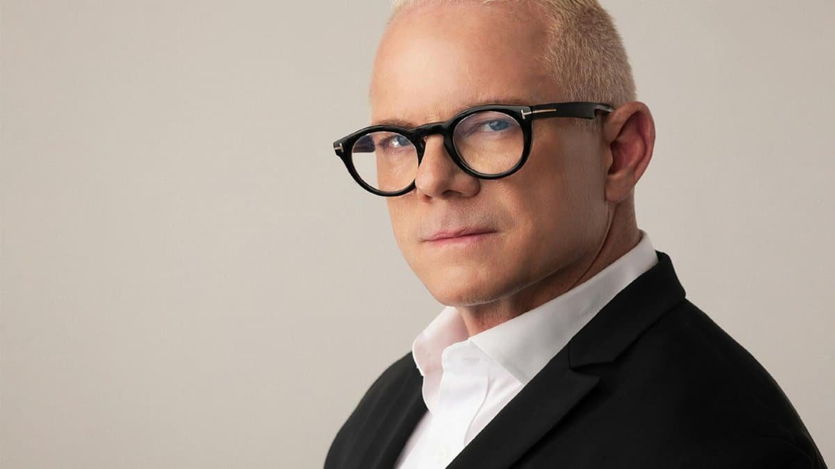 Elegant headshot of a blonde adult man wearing eyeglasses and a suit, perfect for corporate or fashion use.