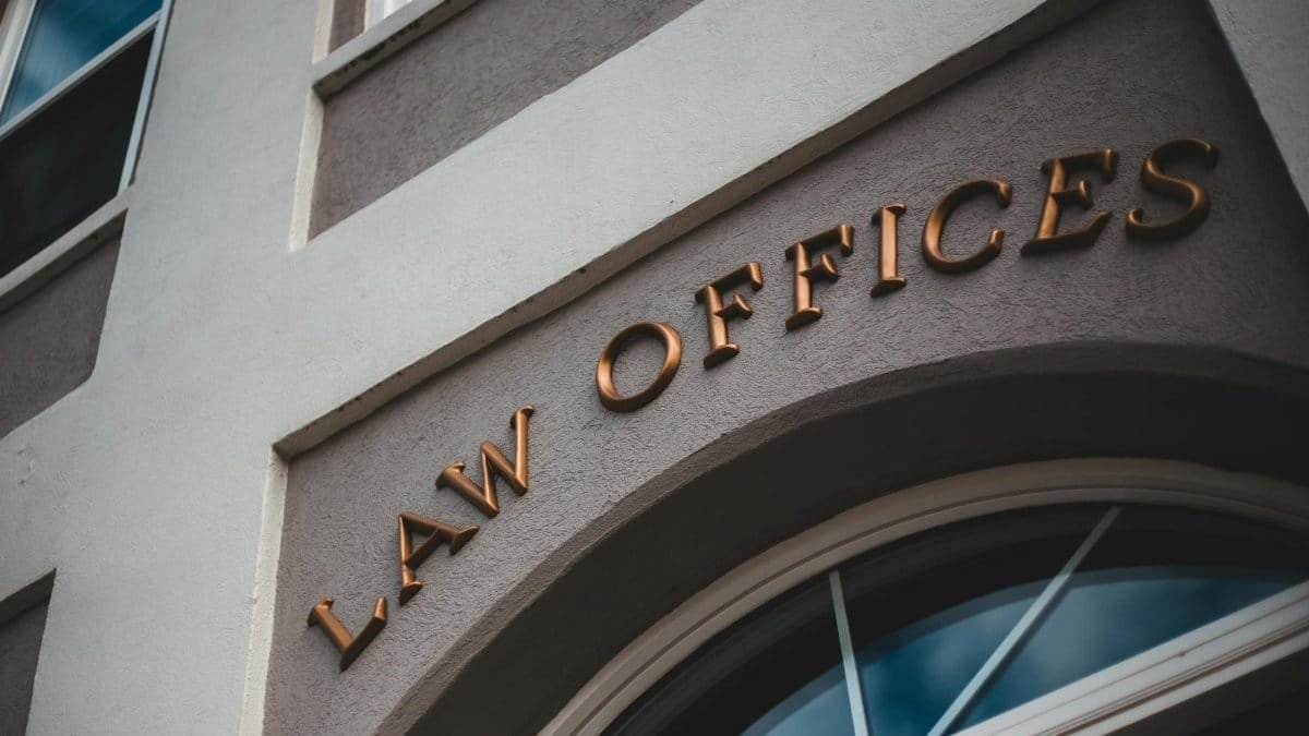 Low angle view of a modern law office exterior with elegant facade and arched entrance.