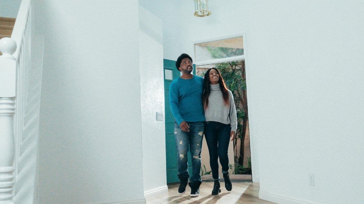 A cheerful couple viewing the interior of their new home, symbolizing new beginnings.