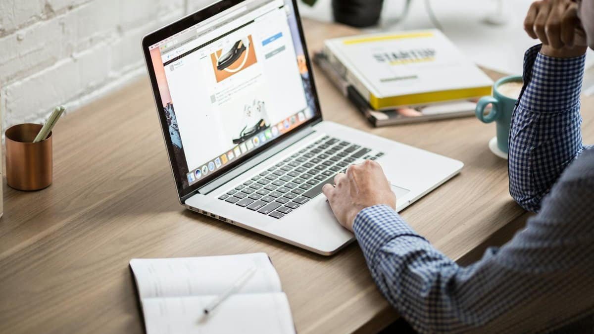 Adult working on a laptop in a modern office setting, illustrating productivity and concentration.