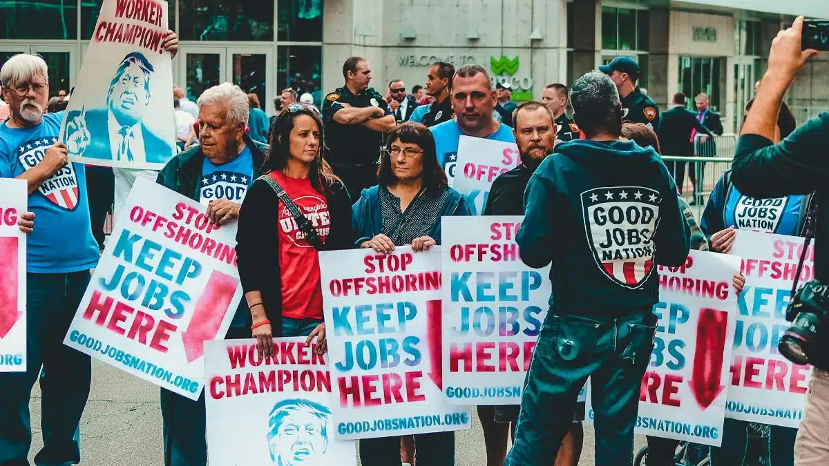 Demonstrators in Wheeling rally against job offshoring with signs for job retention.