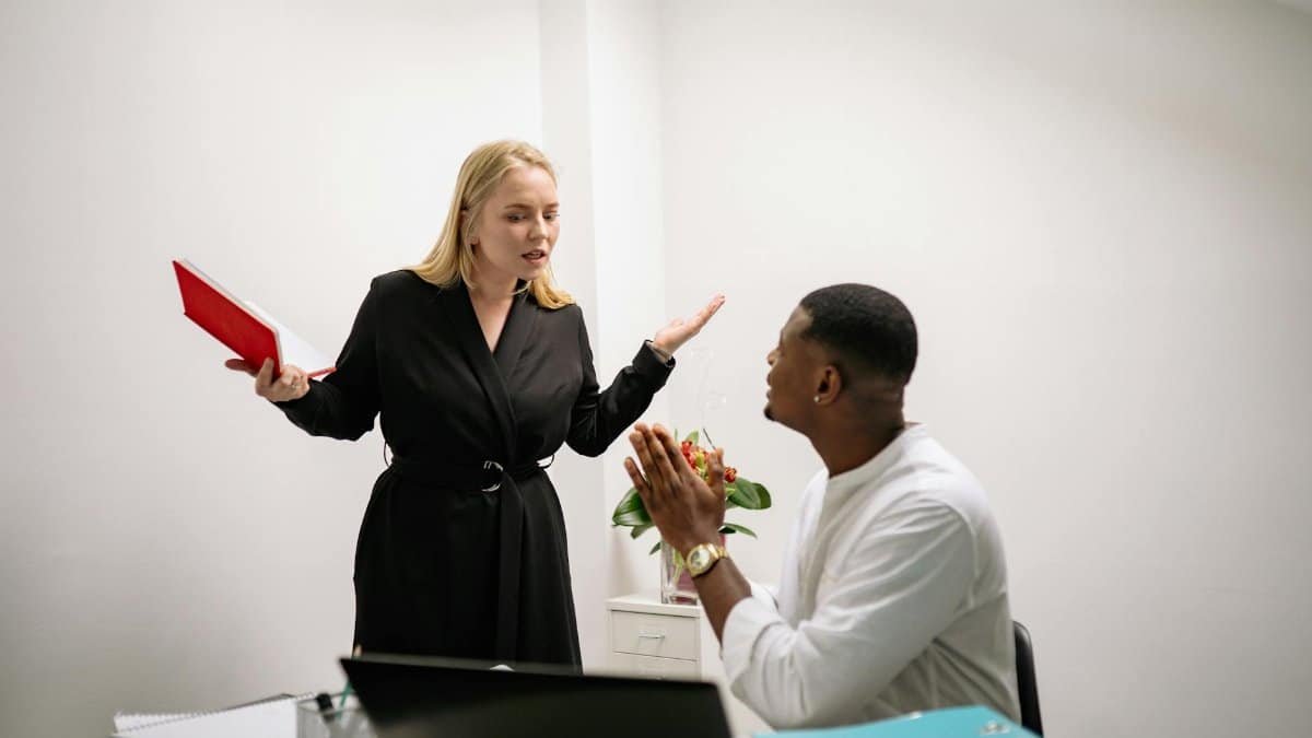 Colleagues in an animated discussion in an office setting, highlighting workplace communication.