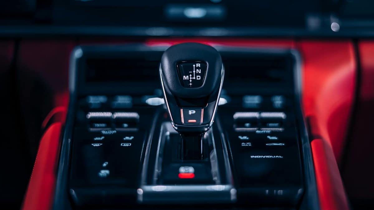 Focus on a sleek car gear shift lever in a luxury vehicle interior.