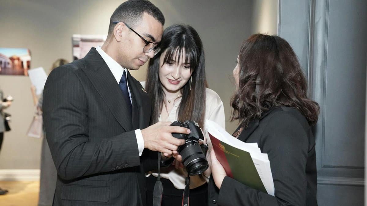 Professionals interacting at a conference, sharing camera insights with a lively discussion.