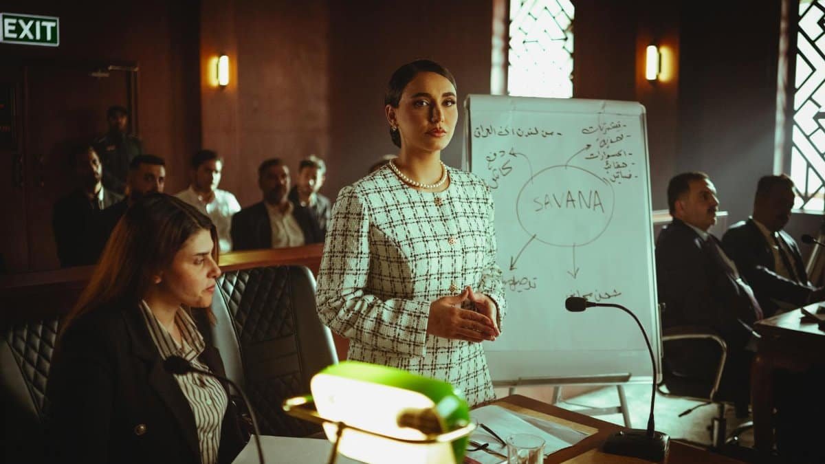 Businesswoman giving a presentation in a modern Baghdad office, engaging with an audience.