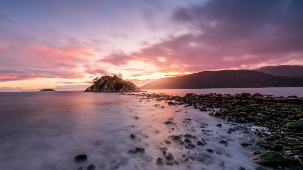 Tranquil island view at sunrise with long exposure creating soft water effect.