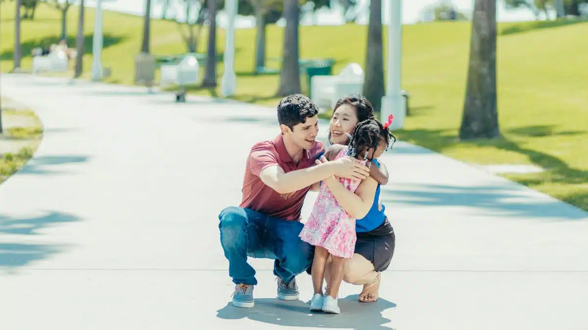 Joyful family hugging in a sunny park, capturing love and happiness.