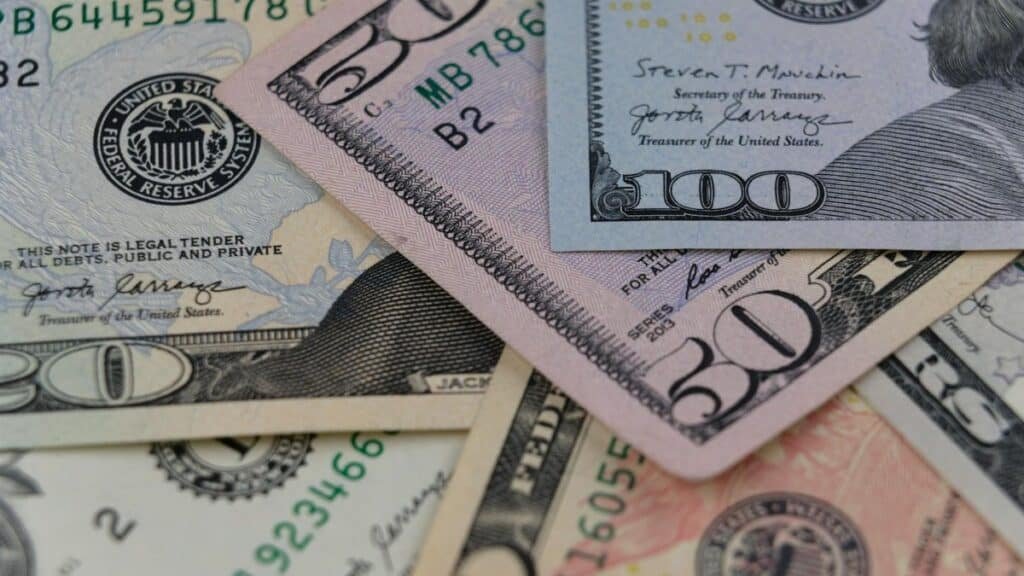 Detailed view of US currency, including $50 and $100 bills, symbolizing finance and economy.