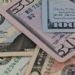 Detailed view of US currency, including $50 and $100 bills, symbolizing finance and economy.