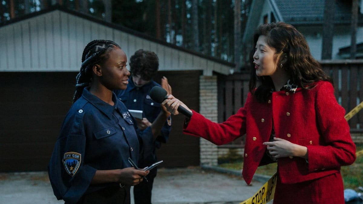 A journalist interviewing a policewoman at a crime scene during twilight.