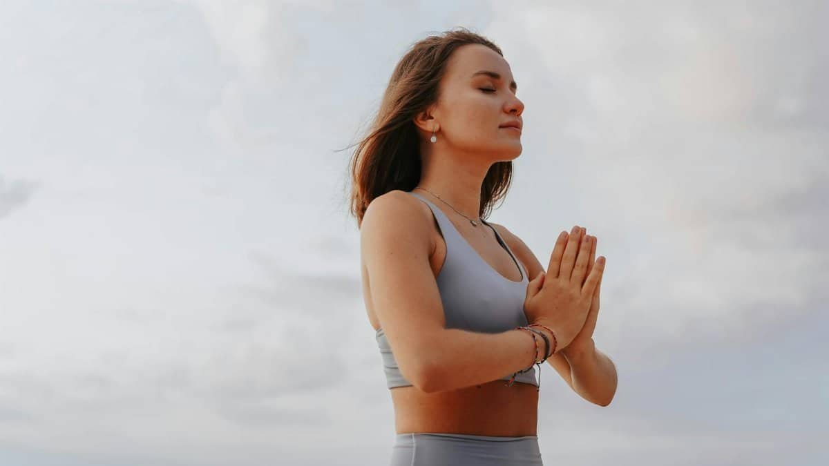 Young woman practicing yoga meditation outdoors, embodying wellness and relaxation.