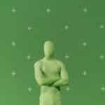 Person in a green chroma key suit standing against a marked green screen in a studio.