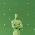 Person in a green chroma key suit standing against a marked green screen in a studio.